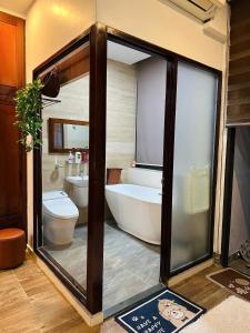 a bathroom with a tub and a toilet and a bath tub at Gold Lucky Homestay in Thôn Trường Giang +137 photos