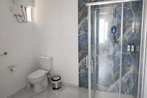 a bathroom with a toilet and a glass shower at Kalimera Studios in Hamrun