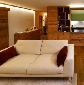 a living room with a white couch with two pillows at Sky nest - Matterhorn in Breuil-Cervinia