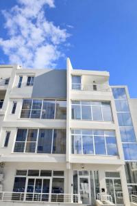 a white building with large windows on the side of it at Kalimera Studios in Hamrun