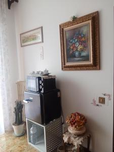 a kitchen with a refrigerator and a painting on the wall at Villa Rosa in Acqualagna