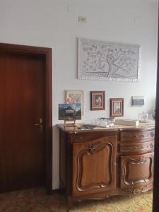 a wooden cabinet in a room with a tree on the wall at Villa Rosa in Acqualagna