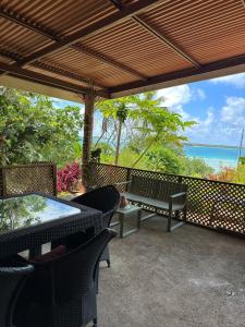 a patio with a table and chairs and the ocean at Pension Vaimano-Raivavae in Vaiuru