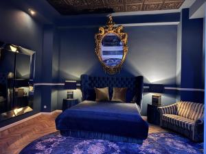 a blue bedroom with a bed and a mirror at Secret Labelle Époque Hideaway in Berlin