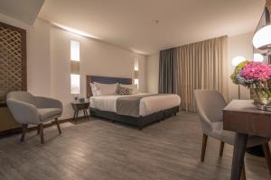 a hotel room with a bed and two chairs at Hotel Santa Catalina By OxoHotel in Cartagena de Indias