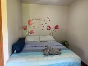 a bedroom with a bed with flowers on the wall at Kohpu garden in Ban Klang