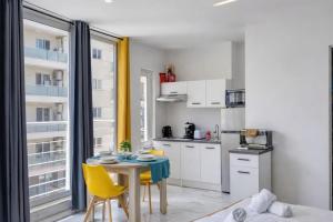 a small kitchen with a table and yellow chairs at Kalimera Studios in Hamrun +4 photos