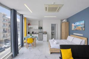 a bedroom with a bed and a table and a kitchen at Kalimera Studios in Hamrun