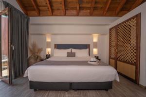 a bedroom with a large bed and a large window at Hotel Santa Catalina By OxoHotel in Cartagena de Indias