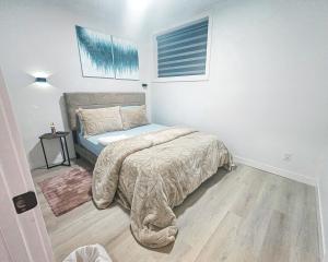 ein Schlafzimmer mit einem Bett und einem Fenster in der Unterkunft Ebenz Apartment in Calgary