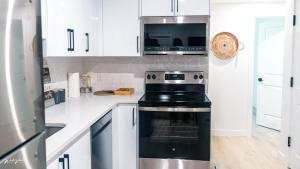 eine Küche mit Herd und Mikrowelle in der Unterkunft Ebenz Apartment in Calgary