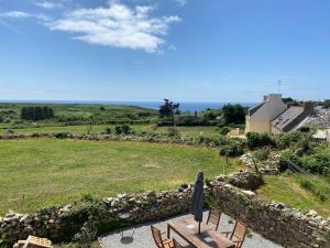a view from the balcony of a house with a stone wall at Tall Ar Groas in Plogoff