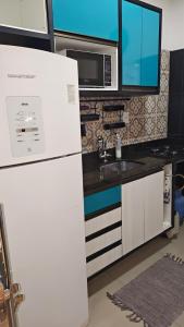 a kitchen with a white refrigerator and a microwave at Boulevard Amazon Suites in Manaus