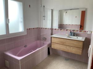a bathroom with a pink tub and a sink at Tall Ar Groas in Plogoff