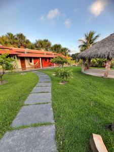 a walkway in a grassy yard with a building at Chalé Rota Das Dunas in Barreirinhas