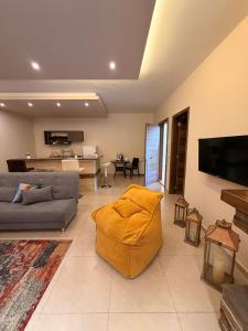 a living room with a couch and a flat screen tv at Austria Luxury Apartments, Faraya Hotel in Fārayyā
