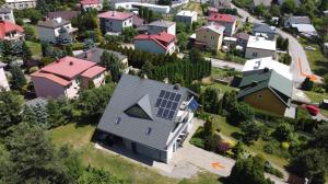 an aerial view of a house with solar panels on it at AzyL25 in Starachowice