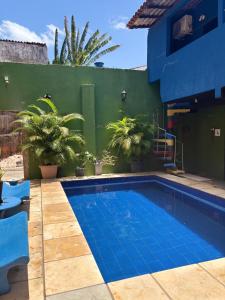 a swimming pool in front of a house with plants at Residência J&M in São Luís