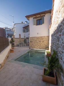a villa with a swimming pool next to a building at La Casina Casa rural con piscina privada y patio cerca de Gredos in Navalcán