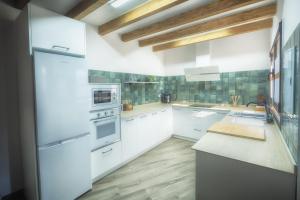 a kitchen with white cabinets and white appliances at La Casina Casa rural con piscina privada y patio cerca de Gredos in Navalcán