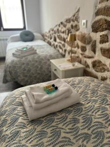 a room with two beds with towels on a bed at La Casina Casa rural con piscina privada y patio cerca de Gredos in Navalcán +32 photos