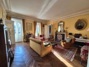 a living room with a couch and a fireplace at Le manoir d'Estiveaux in Le Châtelet
