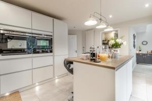 a kitchen with white cabinets and a counter with drinks on it at 3 Bed in Brithdir oc-c33971 in Llanfachreth