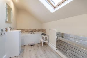 a bathroom with a tub and a sink and a skylight at 3 Bed in Brithdir oc-c33971 in Llanfachreth +32 photos