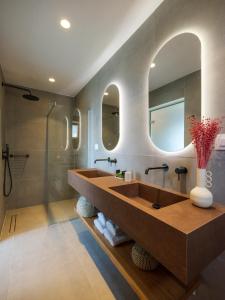 a bathroom with a large sink and a shower at Trinitas Mare Psarou Beach in Psarou