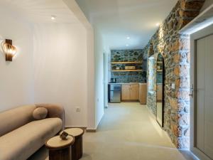 a living room with a couch and a brick wall at Trinitas Mare Psarou Beach in Psarou