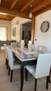 a dining room table with white chairs and a clock on the wall at Blue Petrol Room - Ocean Double Private Suite in Villa Barbuja in Tefía +14 photos