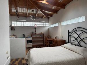a bedroom with a bed and a kitchen with a table at Bungalós brunos in Panajachel +14 photos