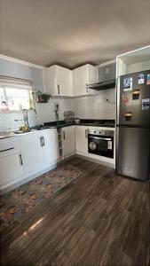 a kitchen with white cabinets and a stainless steel appliance at Cabaña en Ancud in Ancud