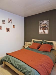 a bedroom with a bed with red pillows at L'Instant Bourguignon in Montceau-les-Mines