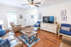 a living room with a couch and a tv at Hello Sunshine in Santa Rosa Beach