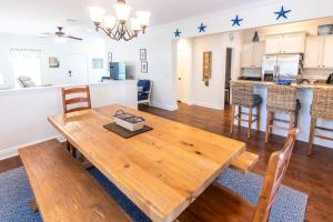 a dining room and kitchen with a wooden table at Hello Sunshine in Santa Rosa Beach