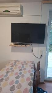 a bedroom with a flat screen tv and a bed at Apartments Oliva - Maslina in Bilice
