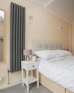 a bedroom with a bed and a side table with a lamp at The Annex @ 136 in Gloucestershire