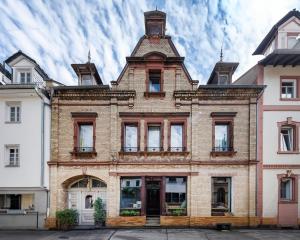 a large brick building with a tower on top at Kaffee&Kissen - Das Boutique Hotel am Rhein in Oestrich-Winkel