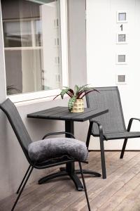 a table with two chairs and a table with a plant at Modern apartment near train station H77A in Narvik