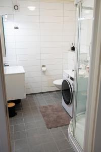 a bathroom with a toilet sink and a washing machine at Modern apartment near train station H77A in Narvik