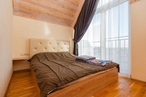 a bedroom with a bed with a large window at Kopų ramybė in Palanga