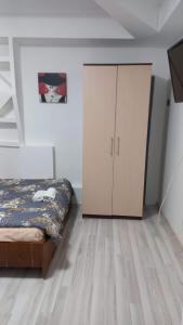 a bedroom with a bed and a cabinet at CASA CU LAVANDĂ in Vatra Dornei