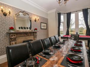 a dining room with a long table with wine glasses at Rocklands in Penrith