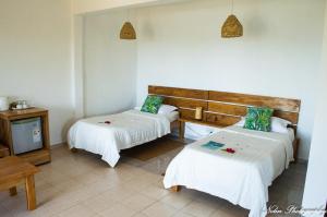 a hotel room with two beds and a tv at La Belle Rodriguaise in Rodrigues Island