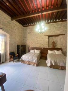 a bedroom with two beds in a stone wall at Casa Alzate in Morelia