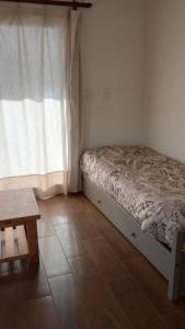 a small bedroom with a bed and a window at Cabaña DEK in Tigre