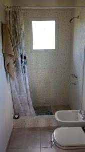a bathroom with a shower and a toilet and a window at Cabaña DEK in Tigre +13 photos