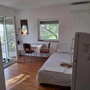 a bedroom with a bed and a table and chairs at Apartments Oliva - Maslina in Bilice