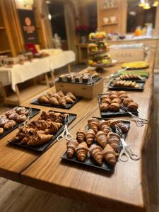a table with many different types of pastries on at Grifone Dolomiti Resort in Arabba +67 photos